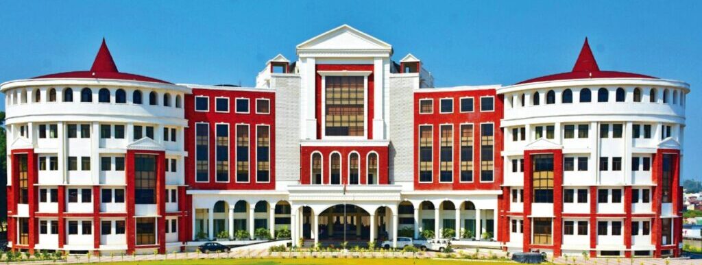 a large red and white building sitting on top of a lush green field